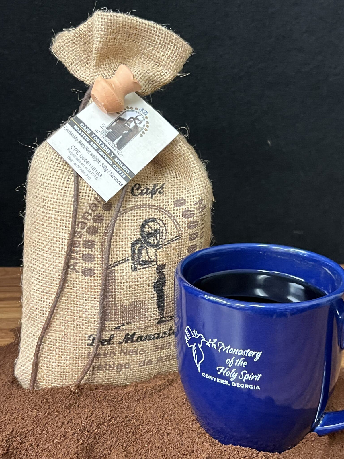 Bag of Monk Venezuelan coffee beside a blue Monastery of the Holy Spirit mug.